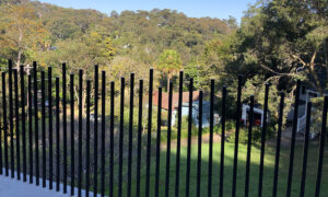 jumbled spear pool fence nominated for fencing awards shows a black blade style fence with alternating heights for each "blade' 